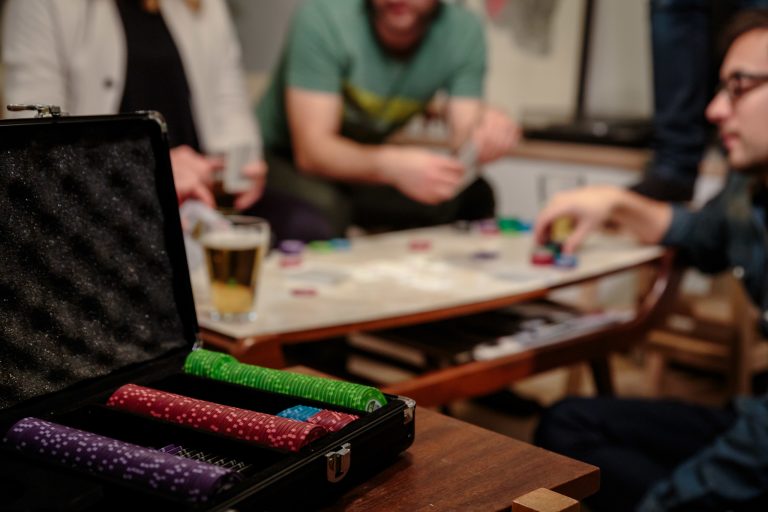 Close up Copag Poker Set with poker chips and people playing in background